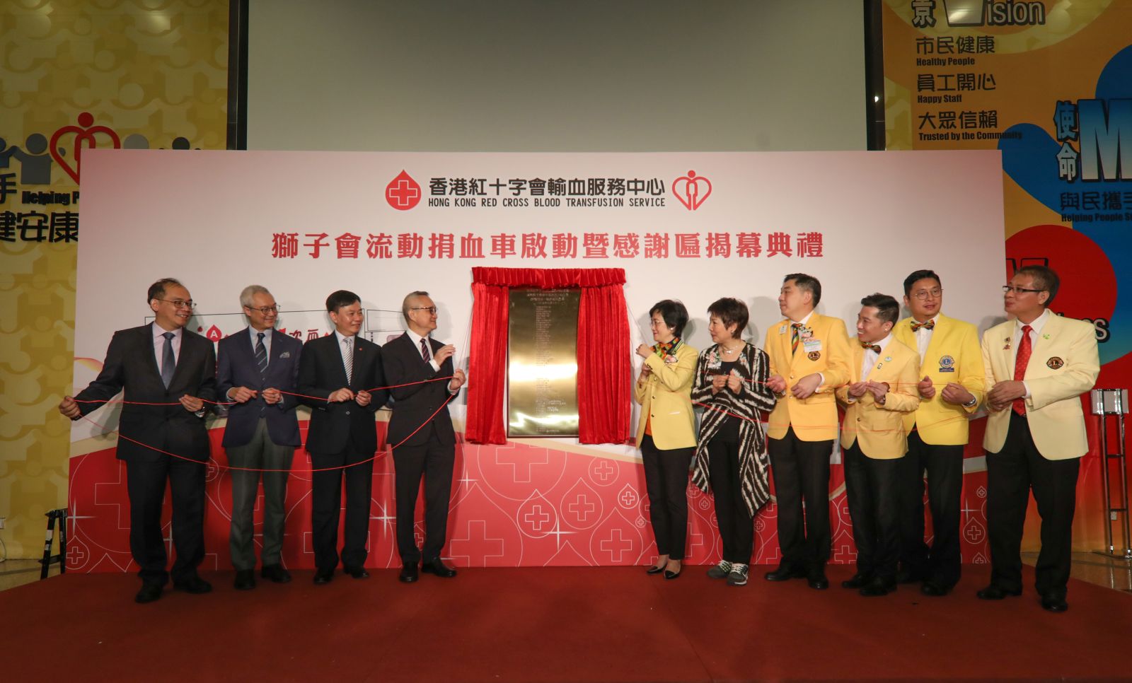 Image: Lions Blood Donation Vehicle on 13 April 2019. (From left) BTS Chief Executive and Medical Director, Dr CK Lee; BTS Governing Committee Chairman, Mr Ambrose Ho; the Hospital Authority Chief Executive, Dr Leung Pak-yin; the Under Secretary for Food and Health, Dr Chui Tak-yi; the District Governor of Lions Clubs International District 303, Hong Kong & Macao, China (Lions Clubs), Ms Mimi Kwok; Past International Director of Lions Clubs International, Ms Teresa Mann; second Vice District Governor of Lions Clubs, Mr John Leung; Lions Club of Sham Shui Po President, Mr Pierre Tse; Lions Club of Kowloon East President, Mr Jose Tan, and Lions Club of New Territories President, Mr Yung Muk Lam, unveiled the plaque of appreciation.