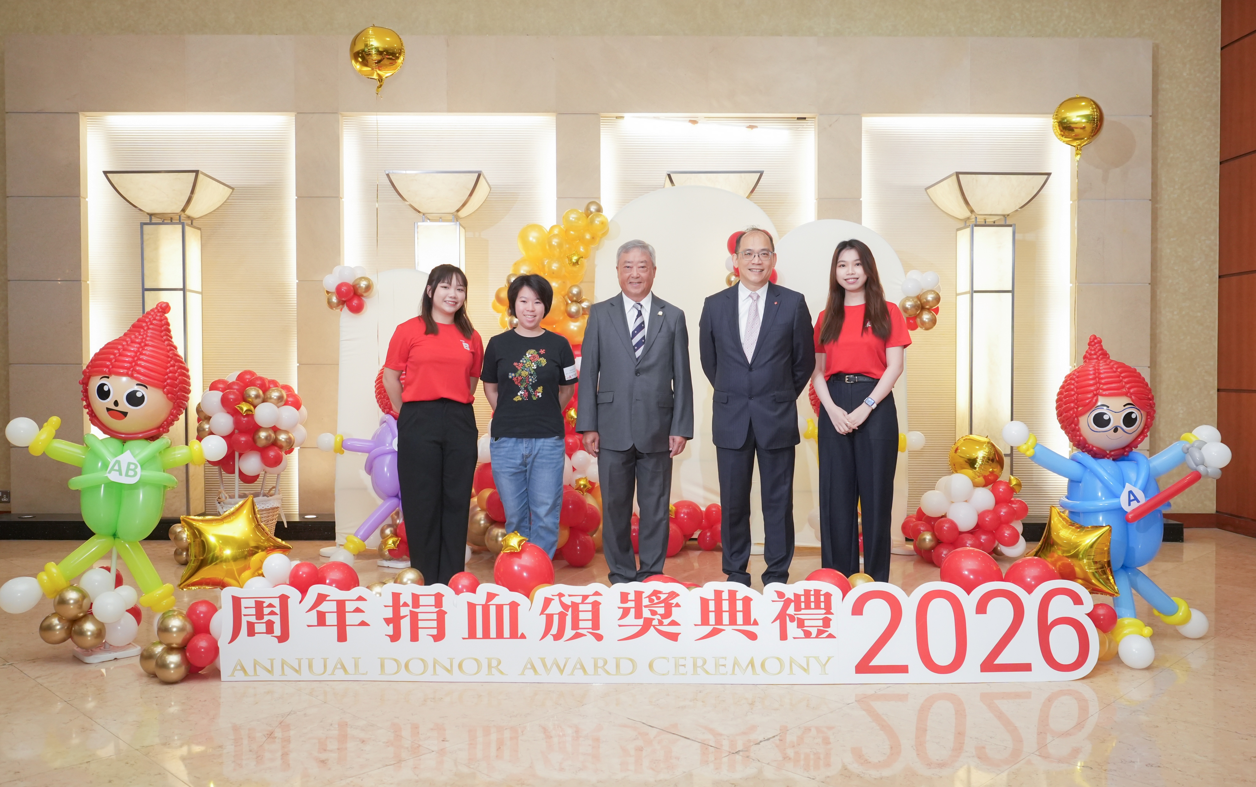 圖片: 香港紅十字會輸血服務中心管治委員會主席陳子政（中）及輸血服務中心行政及醫務總監李卓廣醫生（右二），與本年度獲嘉許的捐血者中最年輕的女捐血者楊皓晴女士（左二），以及兩位來自香港科技大學的學生捐血大使司儀（左一及右一）合照。